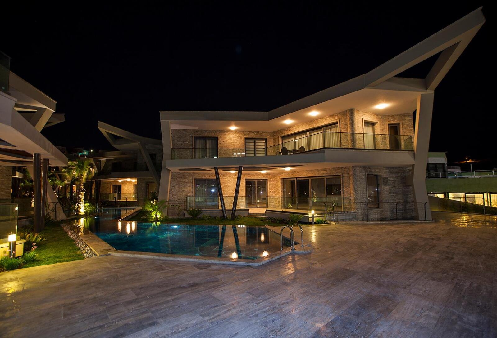 Villa beleuchtet bei Nacht mit Pool – Außenarchitektur Highlight