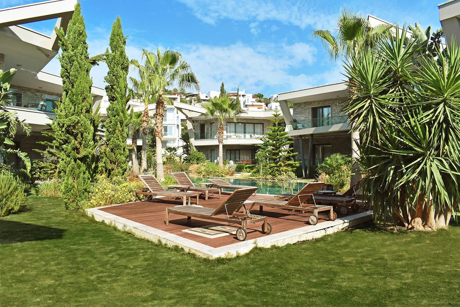 Sonnenschirm und Liegestühle am Pool – Villa Lifestyle