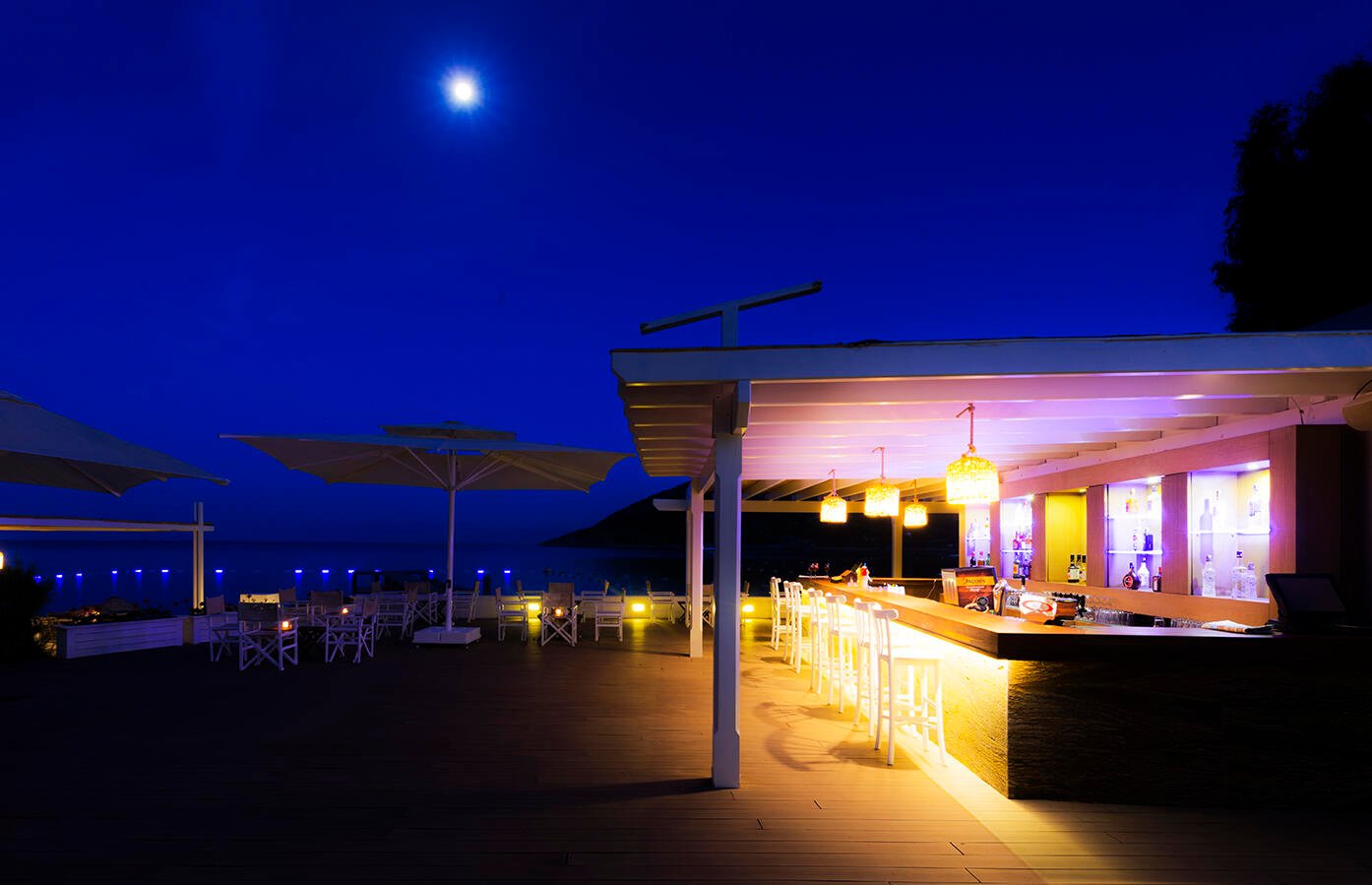 Hotelrenovierung Bodrum mit beleuchteter Poolbar und stimmungsvoller Außenanlage bei Nacht.