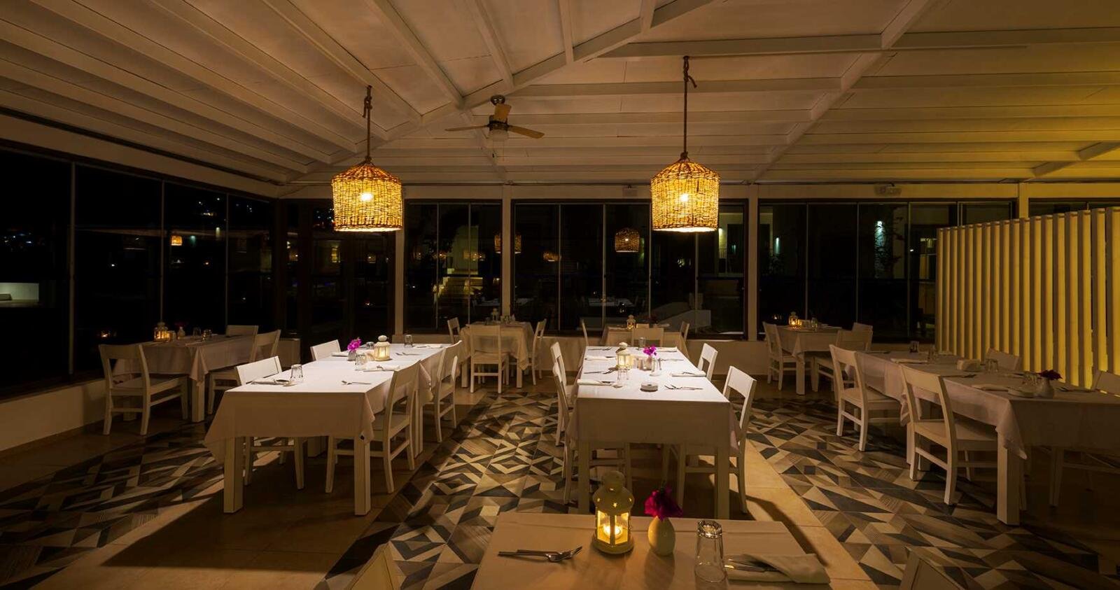 Hotelrenovierung Bodrum mit überdachtem Restaurantbereich und warmer Beleuchtung am Abend.