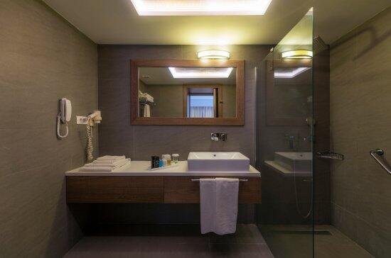 Modernes Hotelbad im LIV Hotel by Bellazure mit Waschtisch, Dusche und funktionaler Ausstattung.