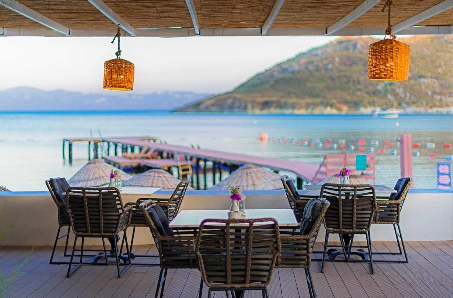 Restaurantterrasse des LIV Hotel by Bellazure mit Sitzplätzen und direktem Meerblick.