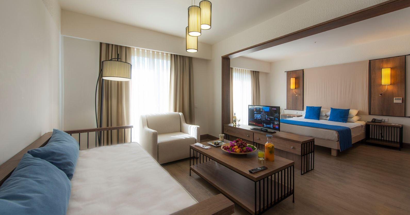 Wohnbereich einer Suite im LIV Hotel by Bellazure mit Sofa, Schreibtisch und Holzmöbeln.