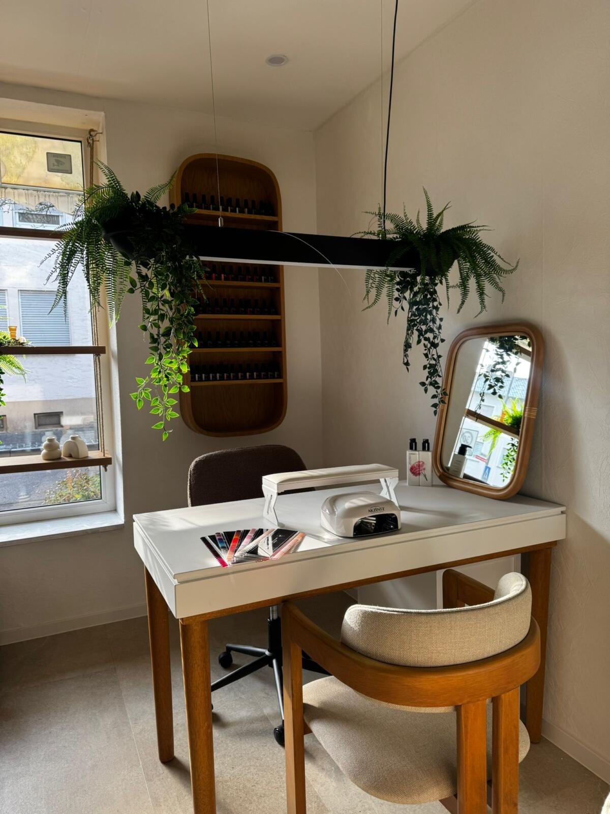 Maniküreplatz mit Tageslicht, Pflanze und funktionaler Arbeitsfläche im Beauty Studio