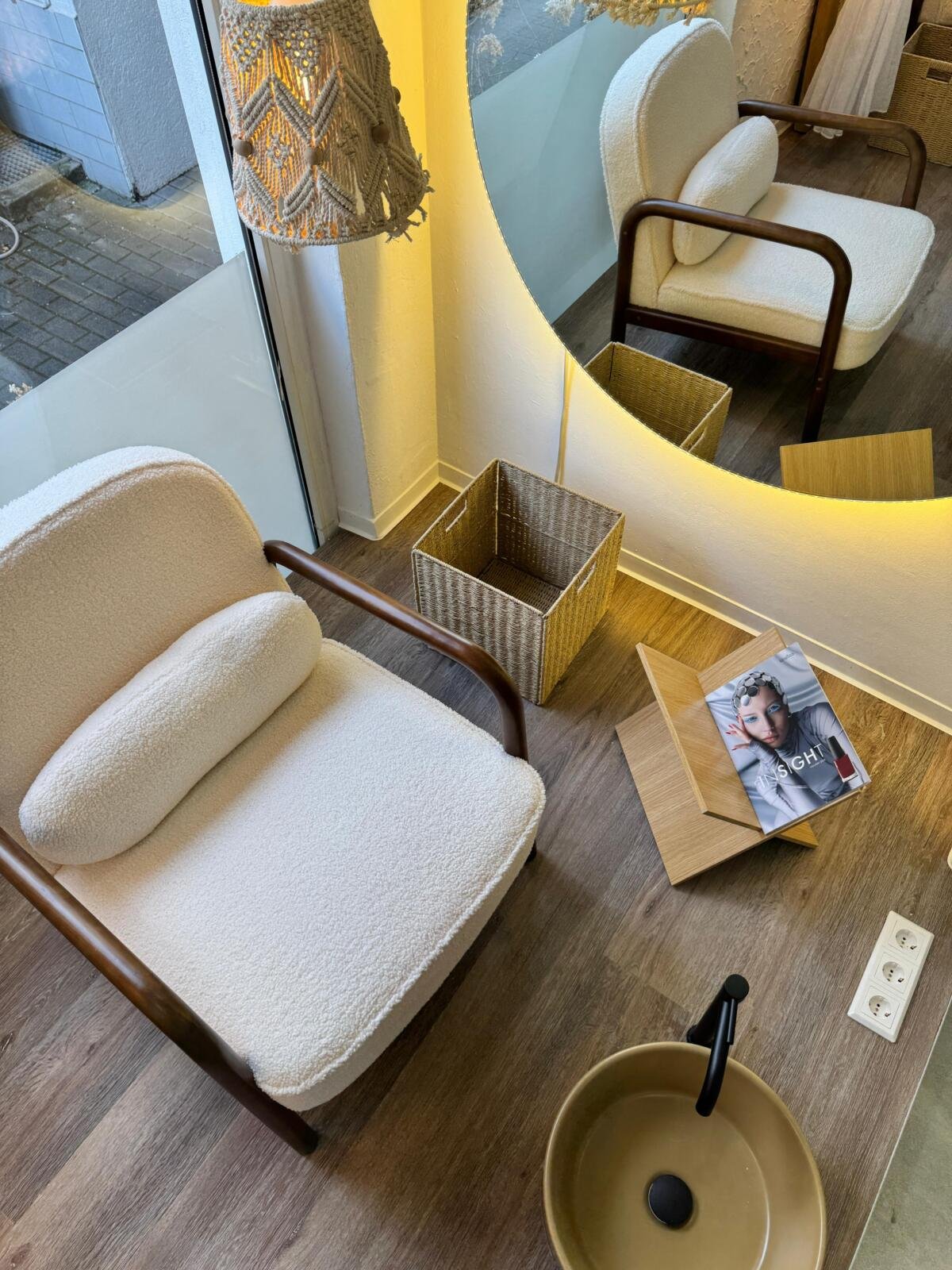 Sesselbereich im Safe.el Beauty Studio mit Beistelltisch, Magazin und indirekter Beleuchtung