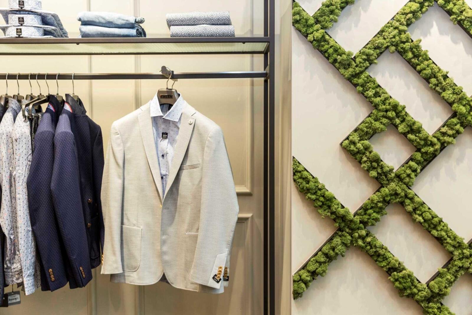 Damat Tween İstanbul Innenarchitektur – Anzugpräsentation mit Pflanzenwand-Hintergrund