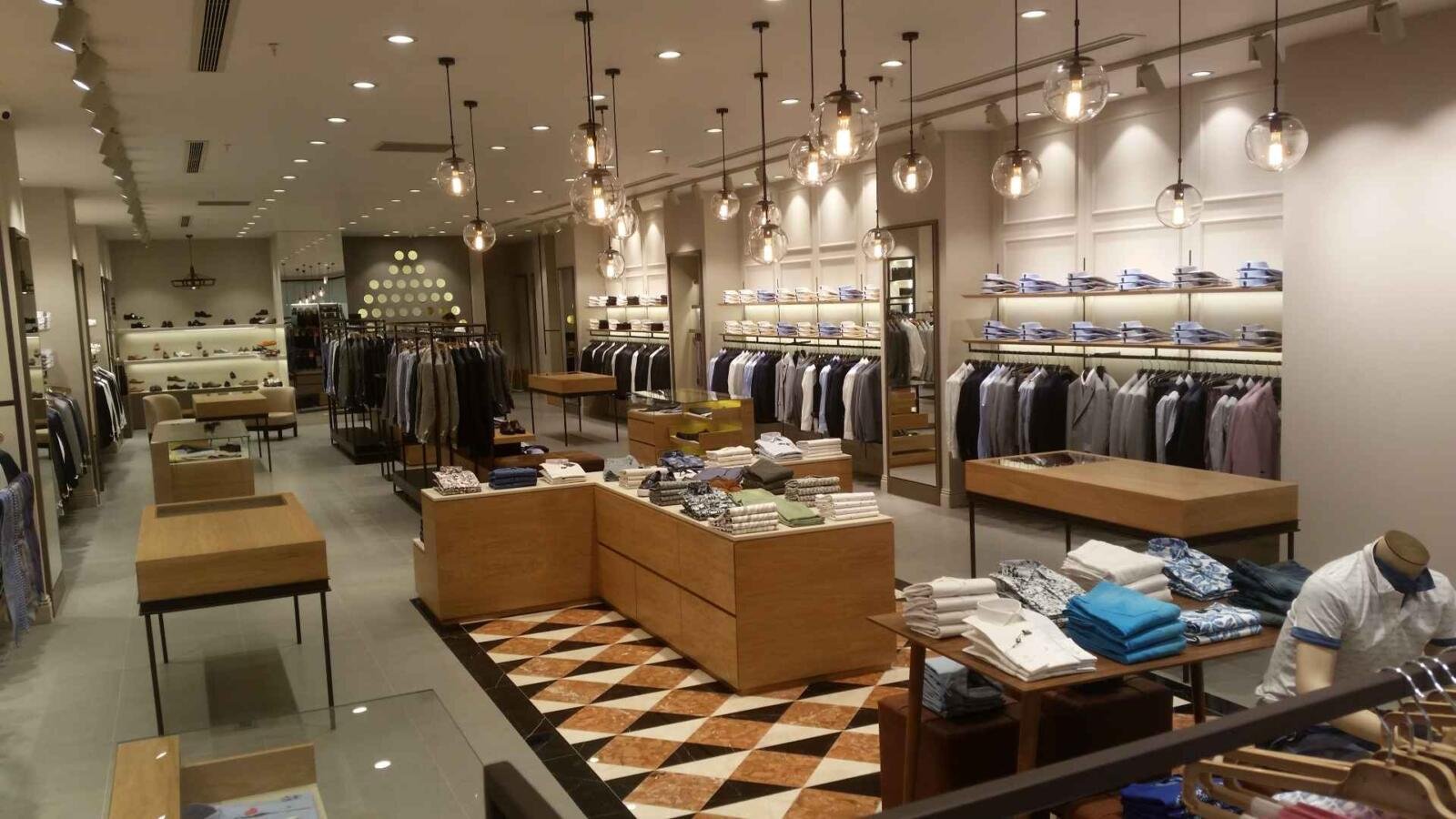 Innenarchitektur – Regalwand mit Herrenmode und Kassenbereich